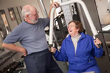 Ældre par træner i fitnesscenter.