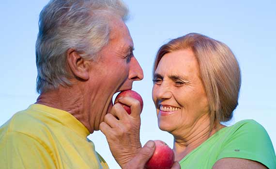 Kvinde giver mand bid af æble.