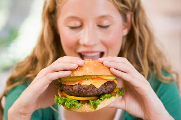 Spiser piger alt for mange burgere kan det betyde adskillige måneders tidligere menstruation. 