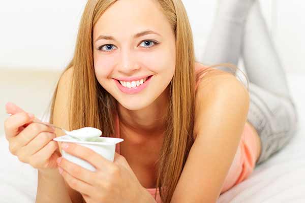 Ung kvinde spiser yoghurt