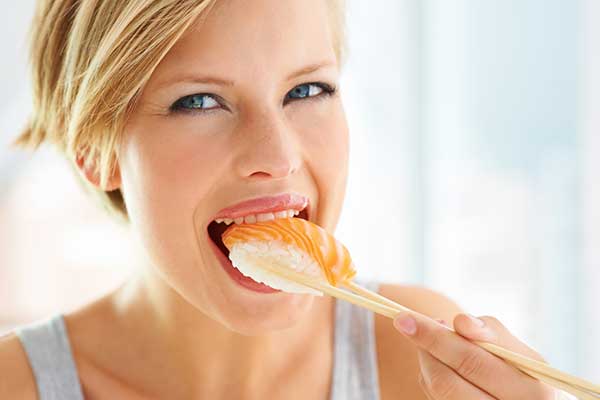 Kvinde spiser sushi.